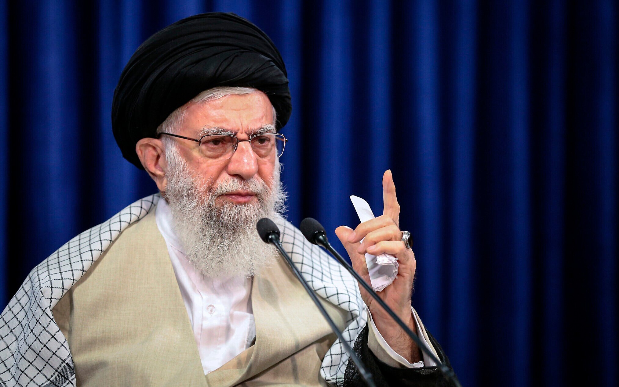 "Ayatollah Ali Khamenei delivering a speech during heightened Israel-Iran tensions, wearing traditional clerical attire and addressing the nation"